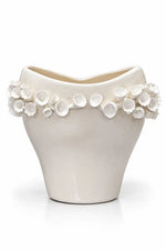 An off-white ceramic planter with a wavy, open top and a decorative border of 3D floral buds around the rim, set against a plain white background.