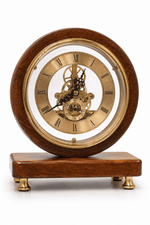 A round wooden mantel clock with a polished dark brown wood frame, brass-toned inner bezel and gears, and a gold-toned dial with Roman numerals, shown on a white background.