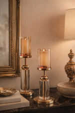 Decorative candle holders on a table with a mirror and lamp in the background