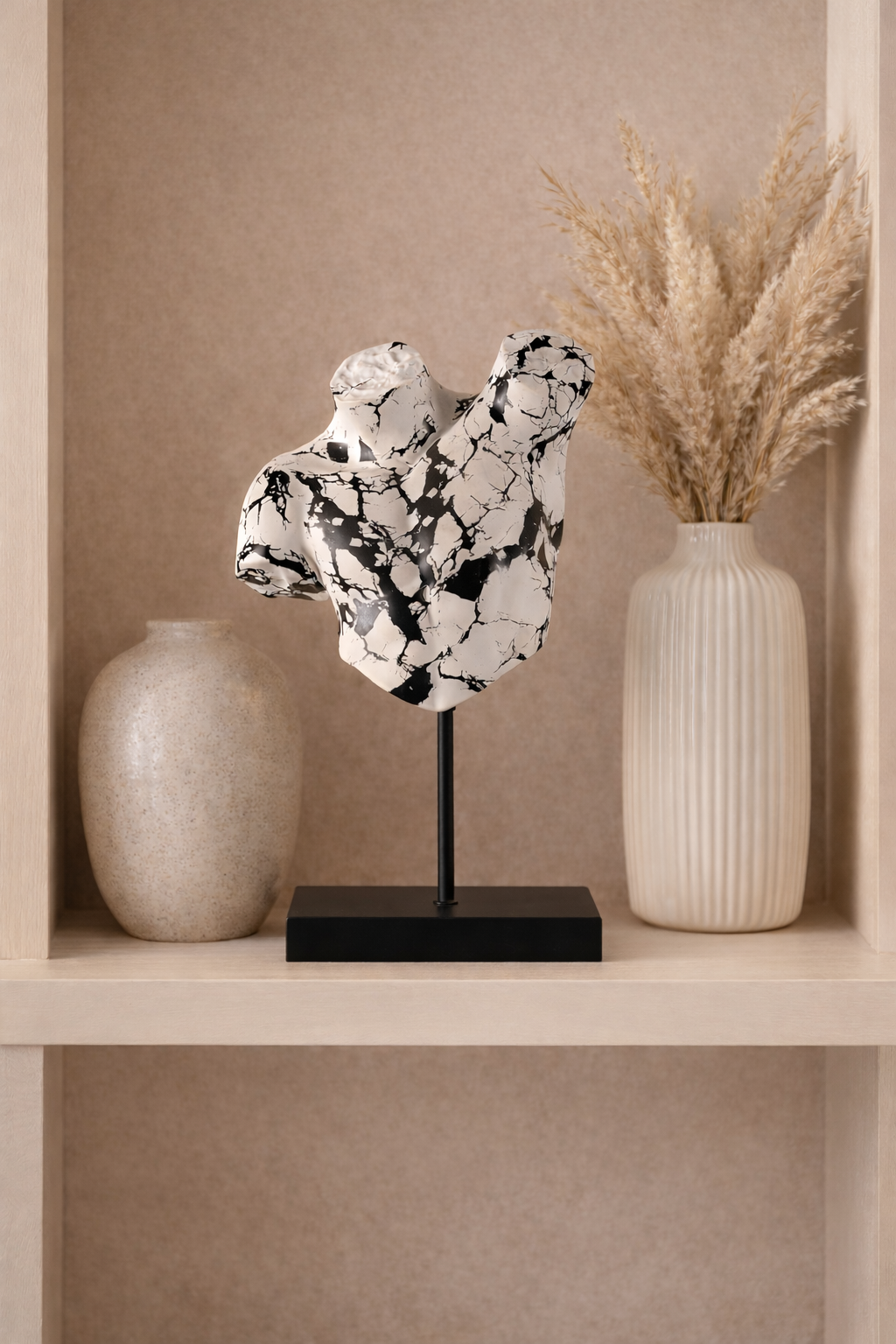Decorative sculpture on a stand with two vases on a shelf against a beige wall.