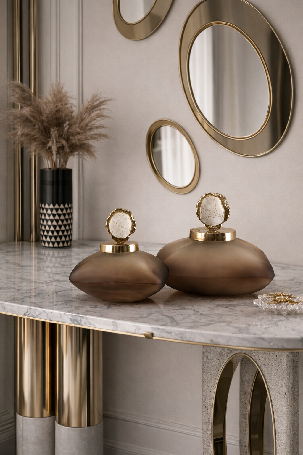Decorative items on a marble surface with gold accents and mirrors in the background.