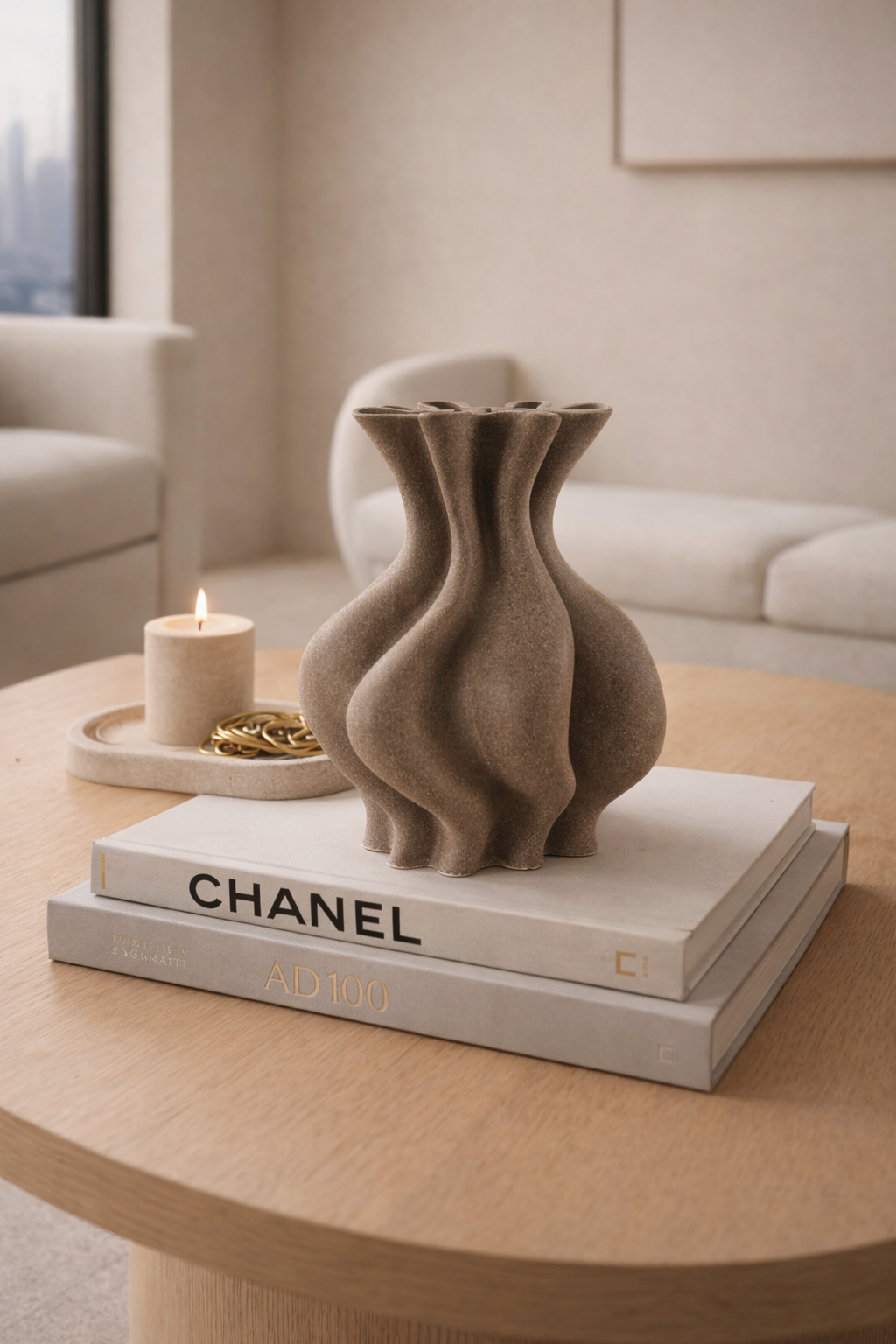 Decorative vase on Chanel books with a candle in the background