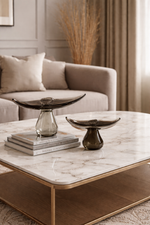 Living room with a marble coffee table, decorative bowls, and a couch.