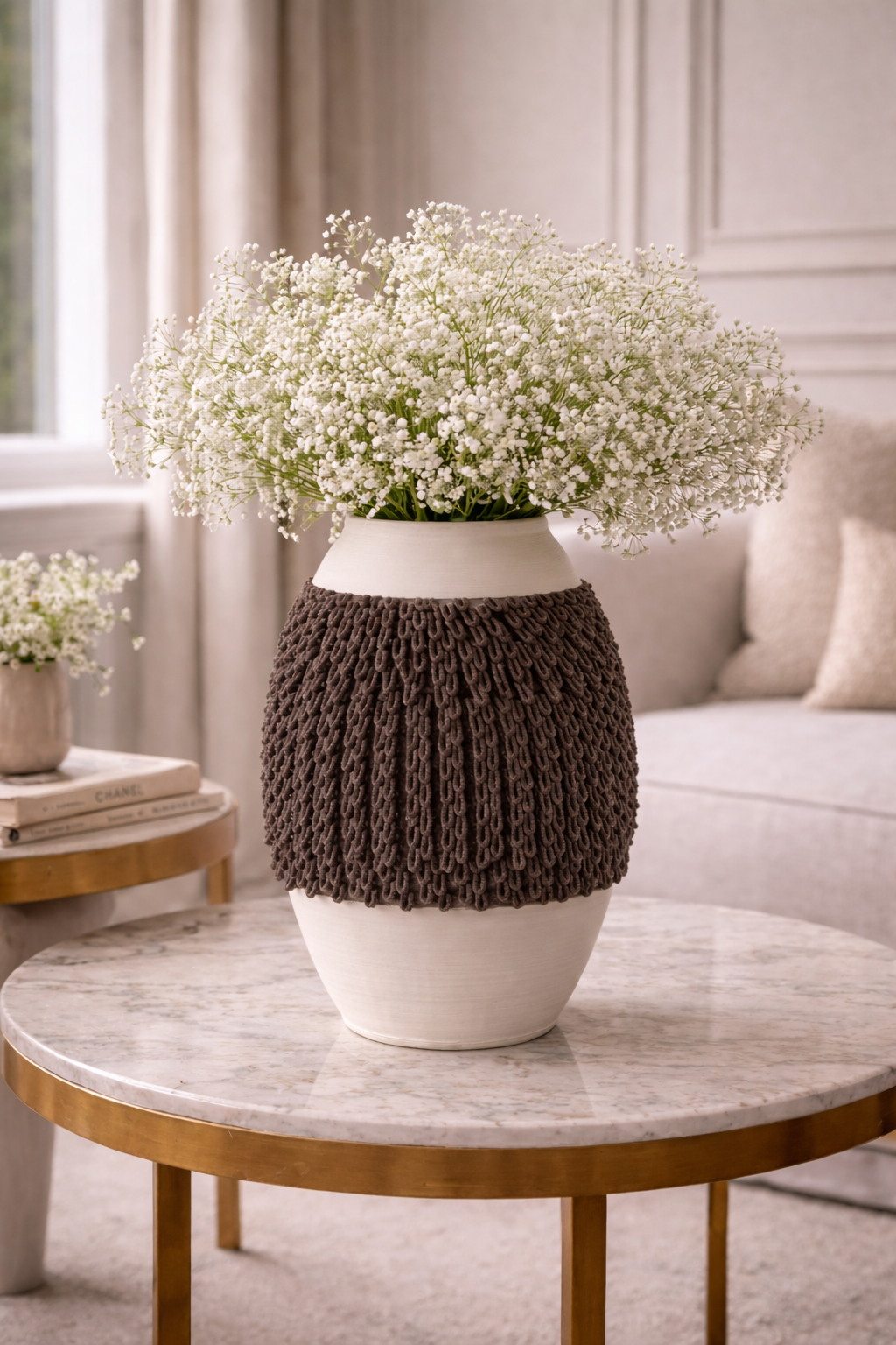 Decorative vase with knitted cover on a marble table in a living room setting