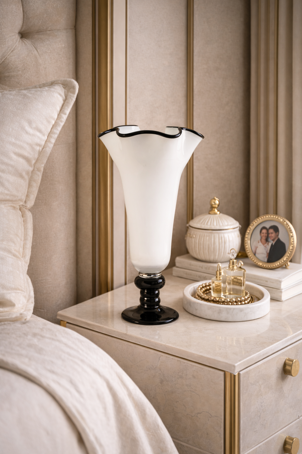 Decorative lamp on a nightstand next to a bed with pillows