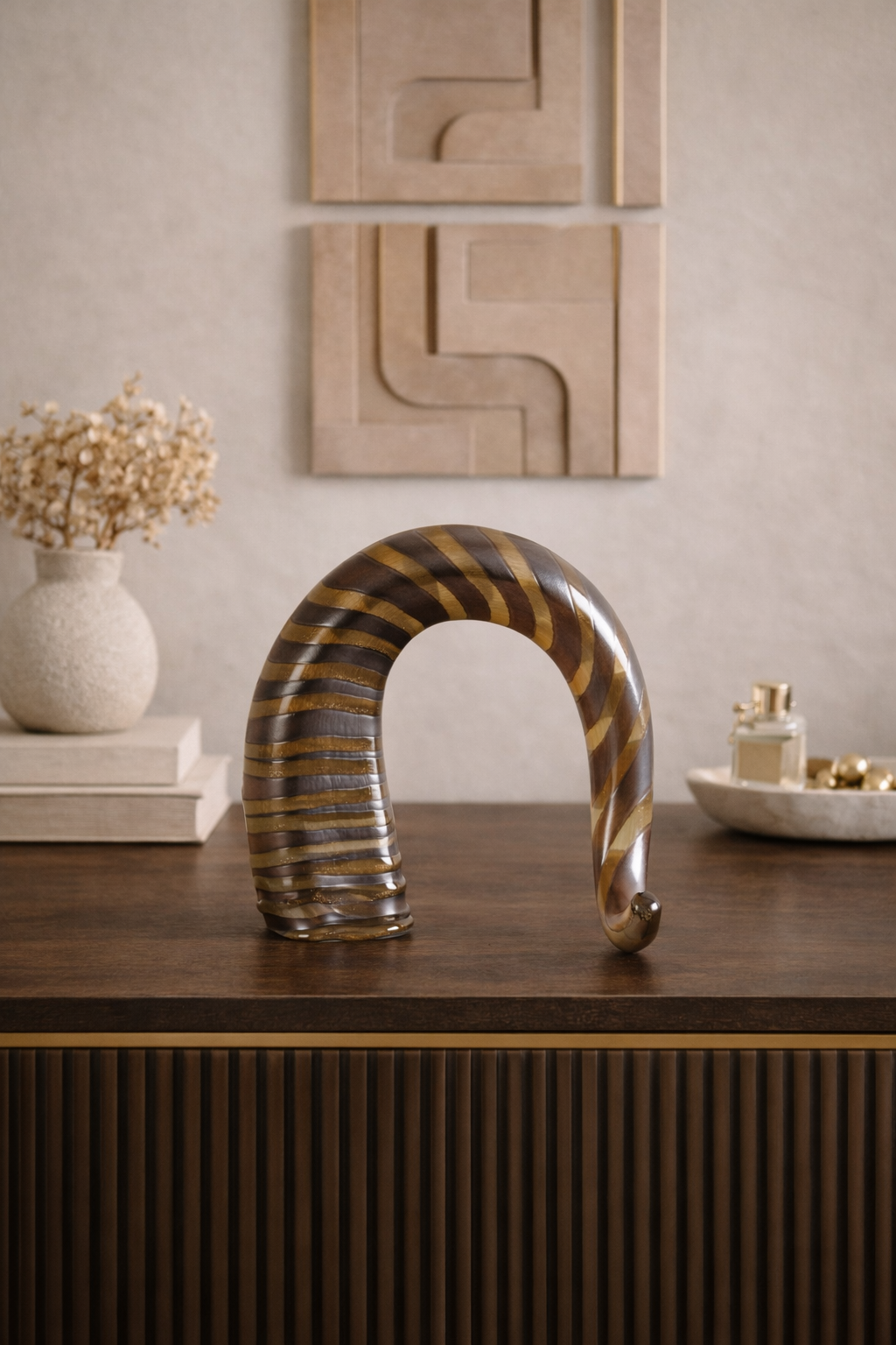 Decorative sculpture on a wooden surface with abstract wall art in the background