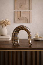 Decorative sculpture on a wooden surface with abstract wall art in the background