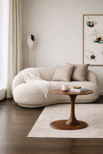 Modern living room with a beige sofa, wooden table, and decorative elements.