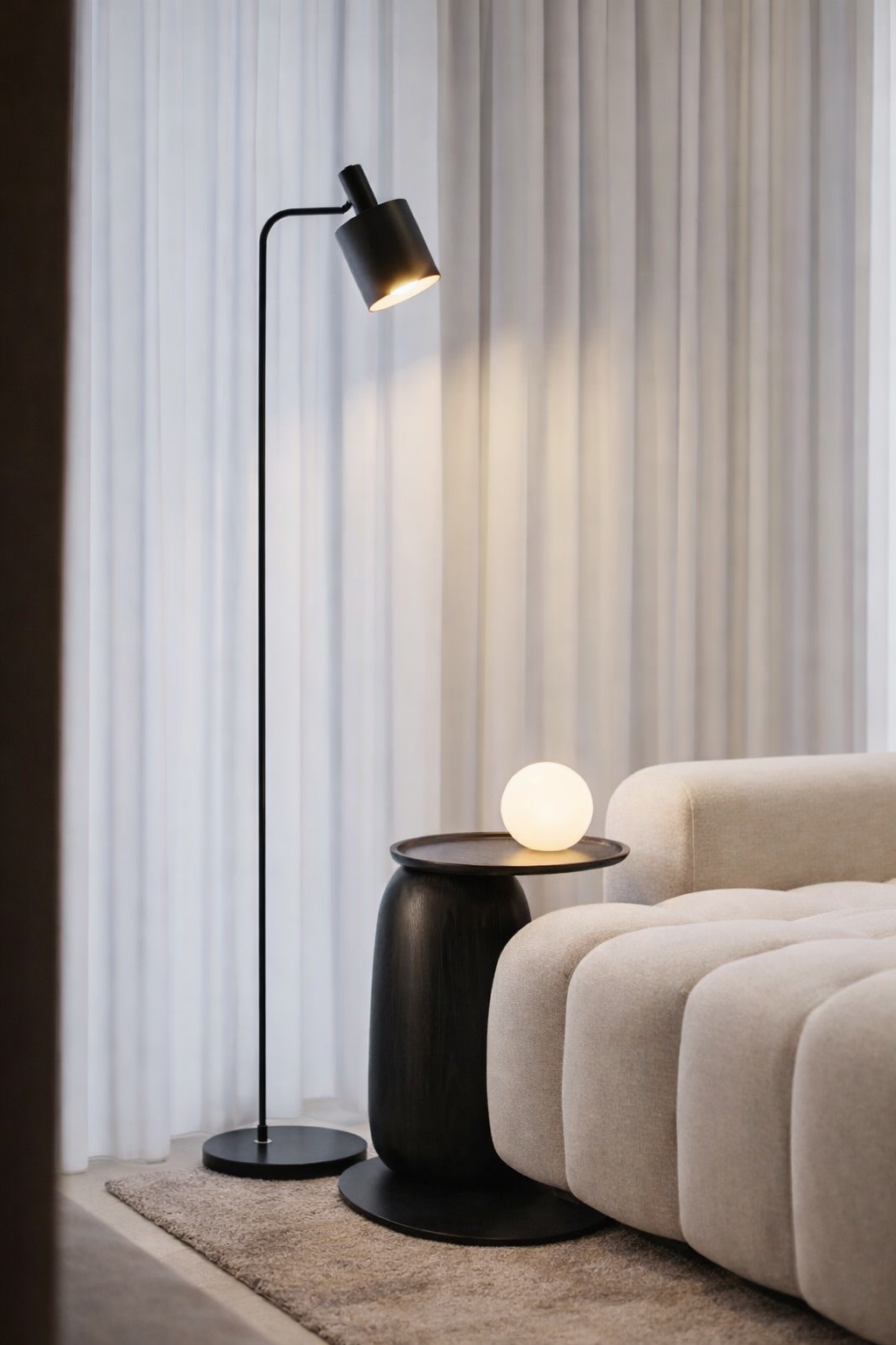 Modern interior with a floor lamp and side table near a sofa.