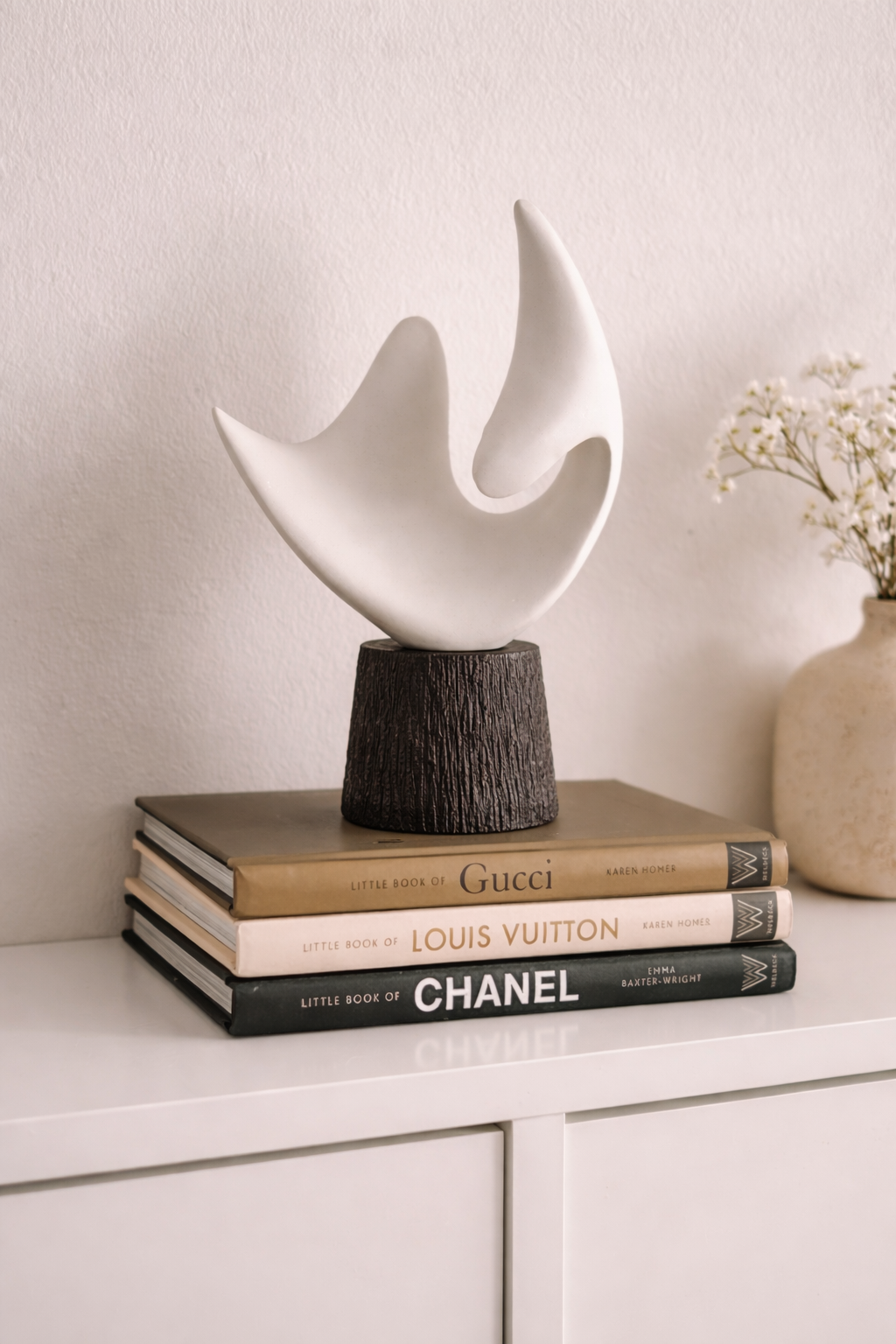 Decorative sculpture on top of books with a neutral background