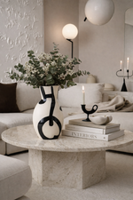 Modern living room with a stone coffee table, decorative vase, and books.