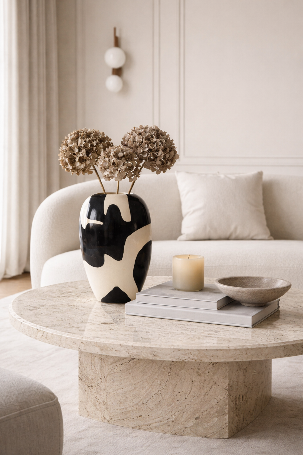 Living room with a marble coffee table, vase with flowers, and books.