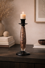 Candle holder with a leopard print design on a wooden surface.