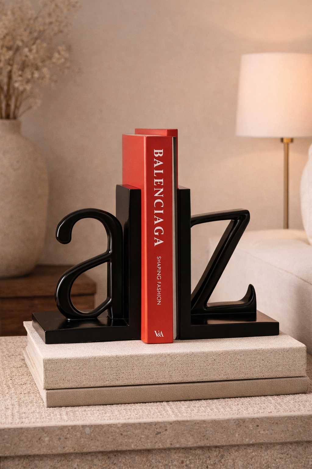 Black letter 'Z' bookends with a red Balenciaga book on a surface.