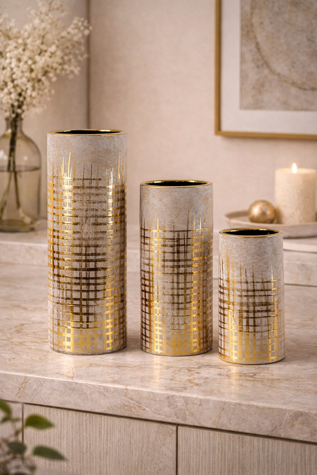 Three decorative vases with gold and gray patterns on a surface.