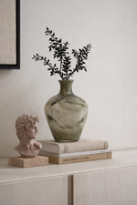 Decorative items including a vase with greenery, a classical bust, and books on a shelf.