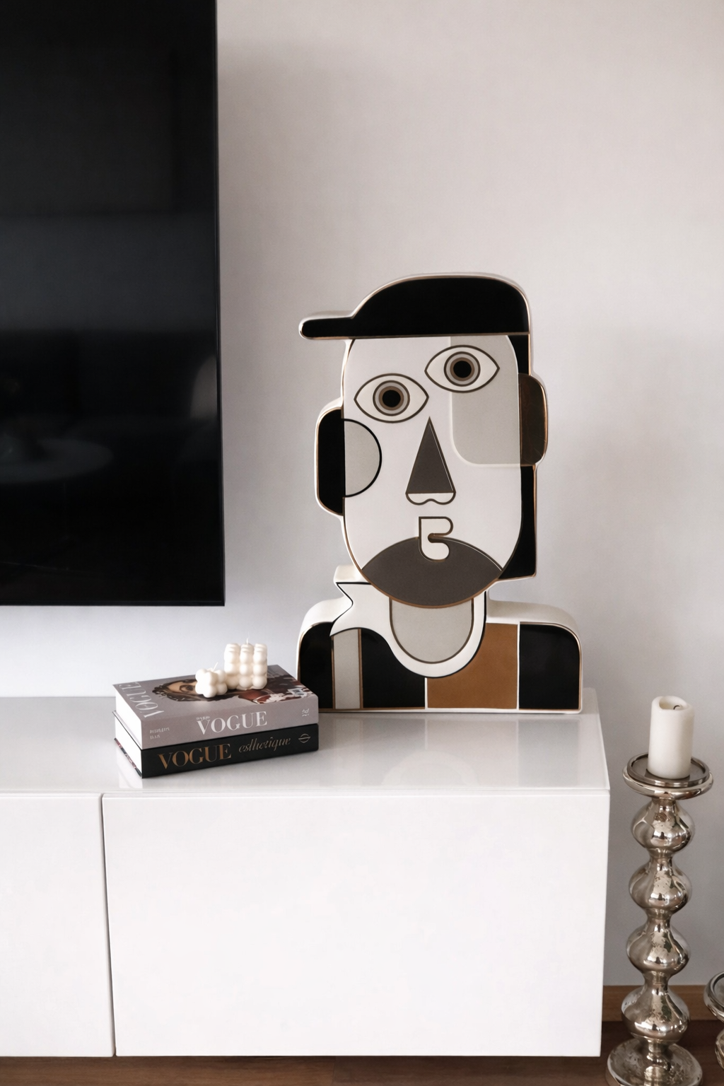 Modern interior design with a stylized face sculpture on a white surface.