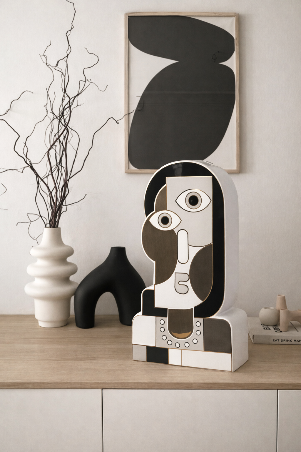 Decorative piece on a shelf with abstract art and vases.