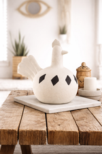 White ceramic teapot with black spots on a wooden table