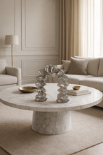 Living room with a marble coffee table, decorative items, and a sofa.