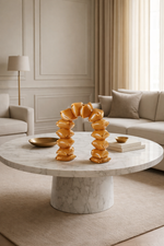Decorative arch sculpture on a marble coffee table in a living room setting.