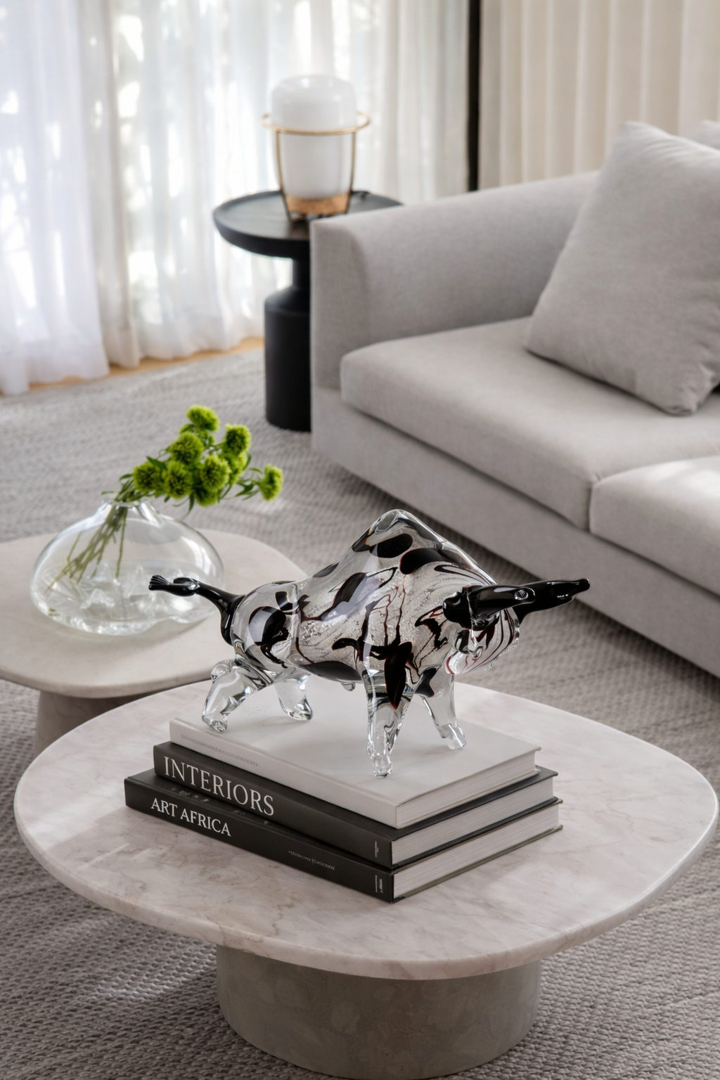 Decorative glass animal figure on books with a modern living room background