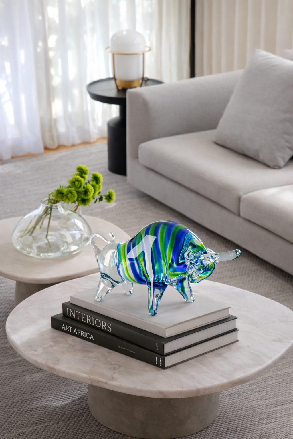 Decorative glass bull on books with a modern living room background