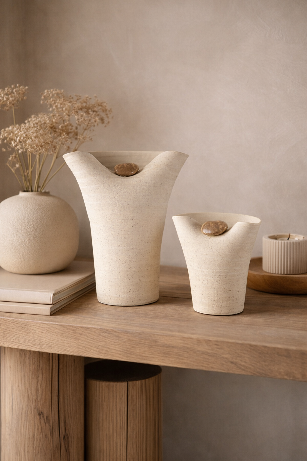 Three ceramic vases on a wooden surface with a neutral background