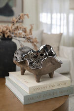 Decorative sculpture on top of books with a blurred indoor setting