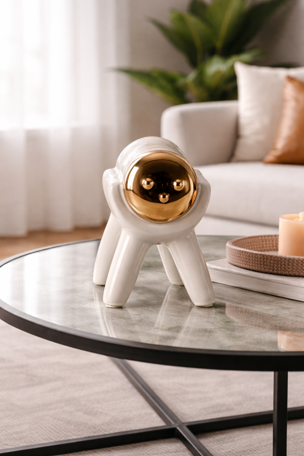 Ceramic astronaut figurine on a glass coffee table in a living room setting.