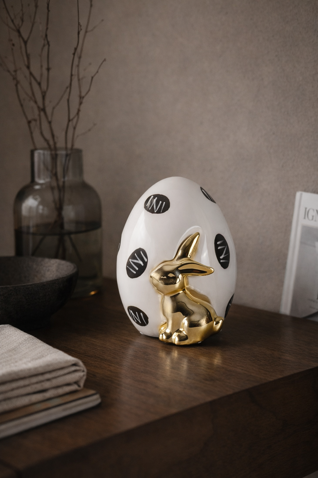 Decorative egg with gold rabbit on a wooden surface