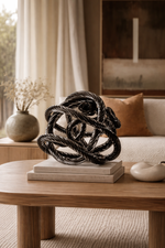 Decorative black sculpture on a wooden table in a living room setting