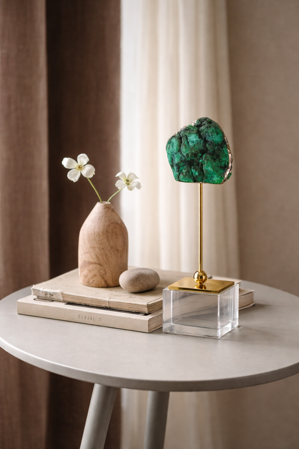 Decorative items including a vase with flowers, a green crystal, and books on a table.