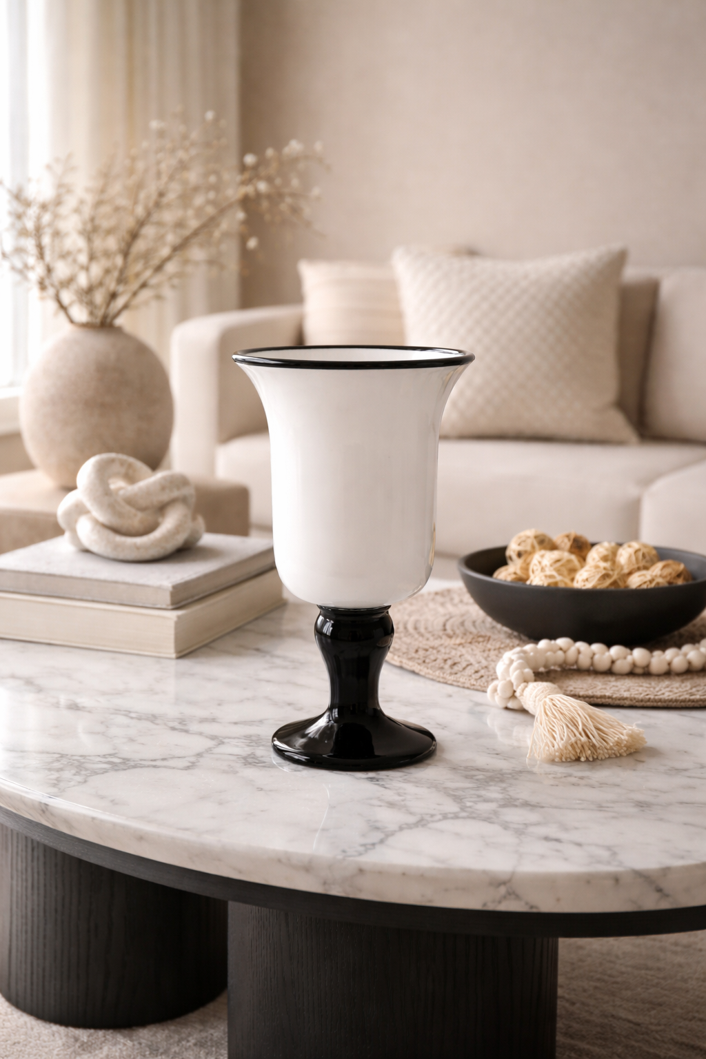 Decorative vase on a marble coffee table with a neutral-colored sofa and decor in the background