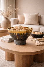 Decorative bowls on a wooden coffee table with a neutral-colored sofa and decor in the background.