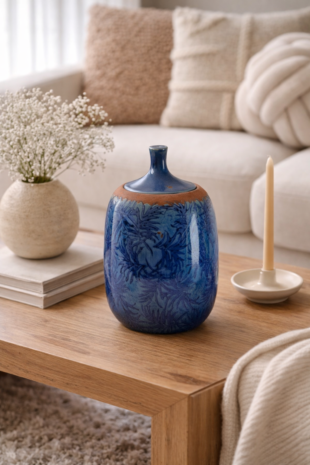 Blue ceramic jar on a wooden coffee table with a neutral-colored sofa in the background