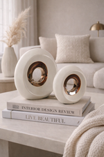 Decorative white sculptures on books with a cozy living room background