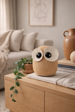 Wooden owl-shaped decorative item on a wooden surface in a cozy living room.