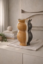 Two-tone ceramic vase on a surface with a neutral background