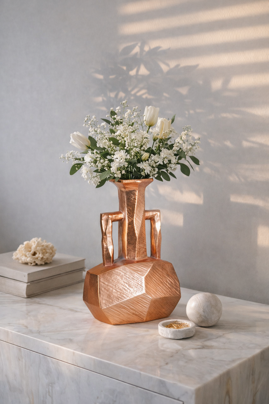 Copper vase with flowers on a marble surface