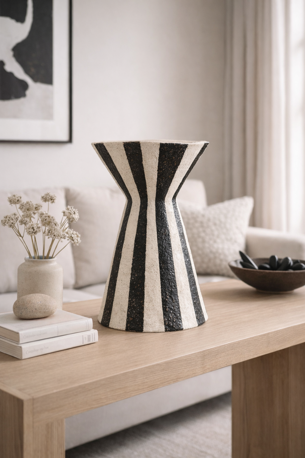Black and white striped vase on a wooden table in a living room setting