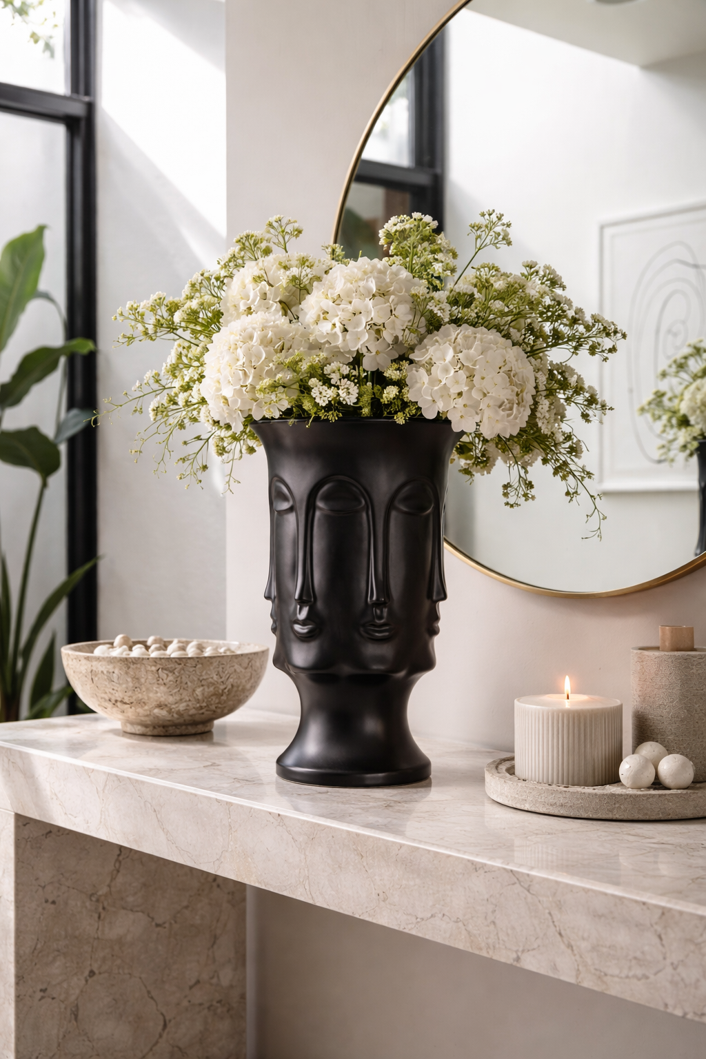 Decorative black vase with floral arrangement on a marble surface