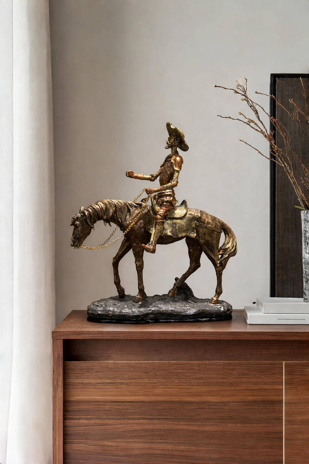 Bronze sculpture of a person on horseback on a wooden surface