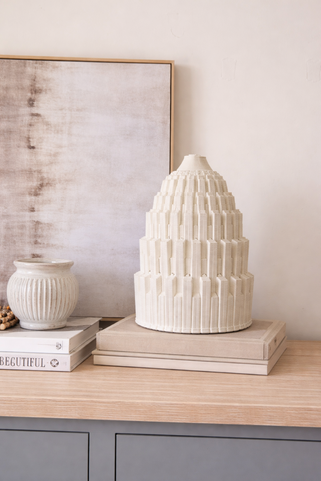 White ceramic sculpture on a wooden surface with a neutral background