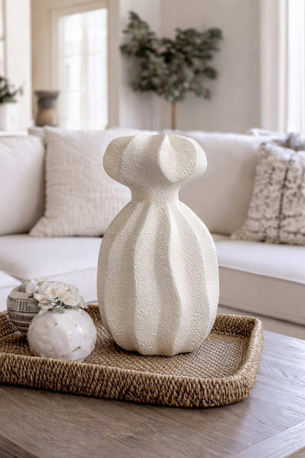 Decorative vase on a woven tray with a blurred living room background