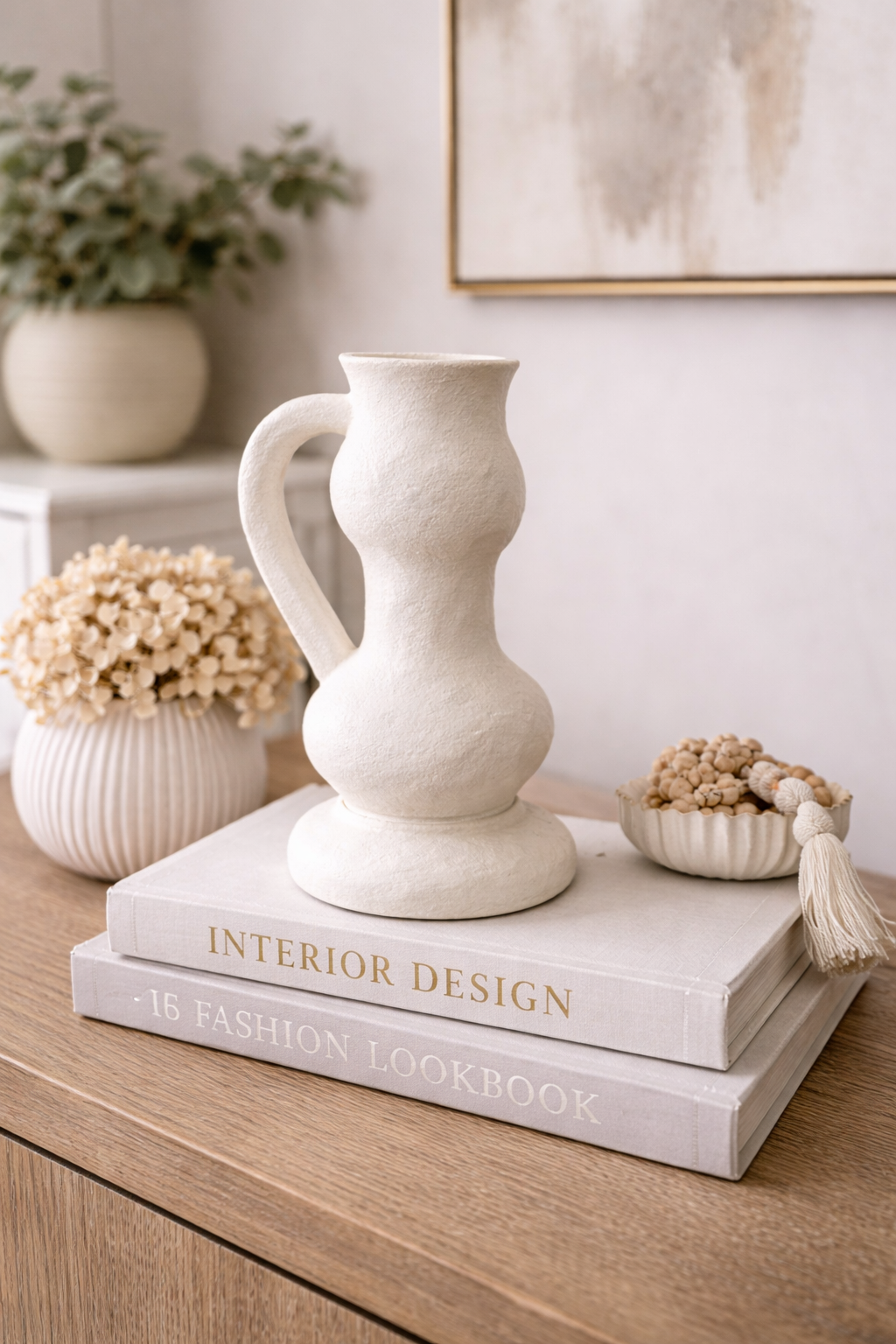 Decorative white vase on top of books with a neutral background