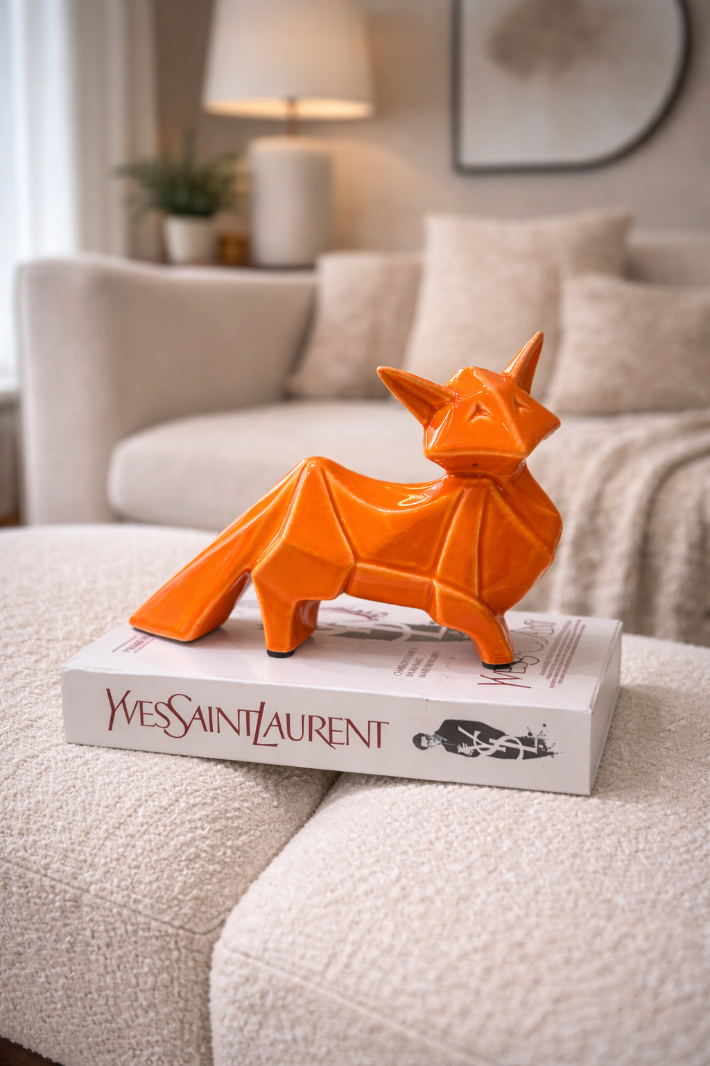 Orange fox figurine on a Yves Saint Laurent box in a living room setting