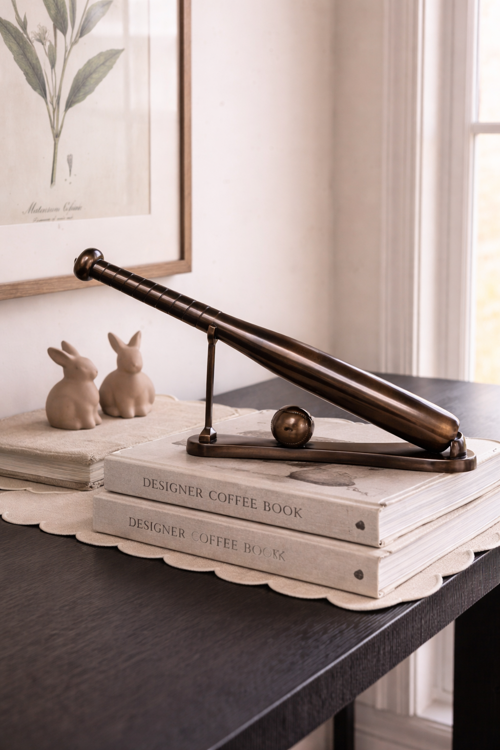 Decorative item on a stack of books with a framed picture in the background