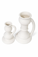 Two white ceramic candle holders on a white background
