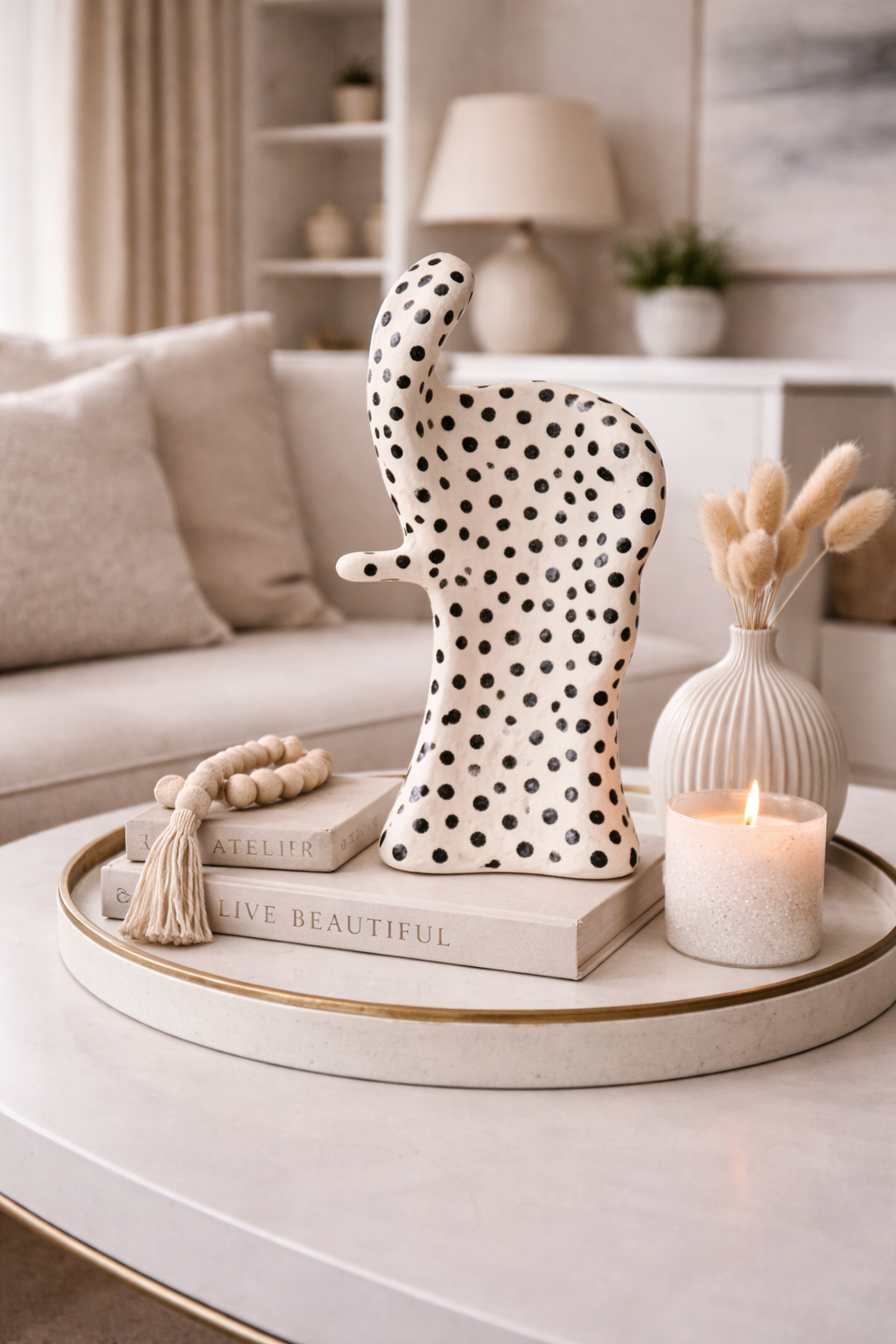 Decorative elephant figurine with black dots on a coffee table in a living room setting.